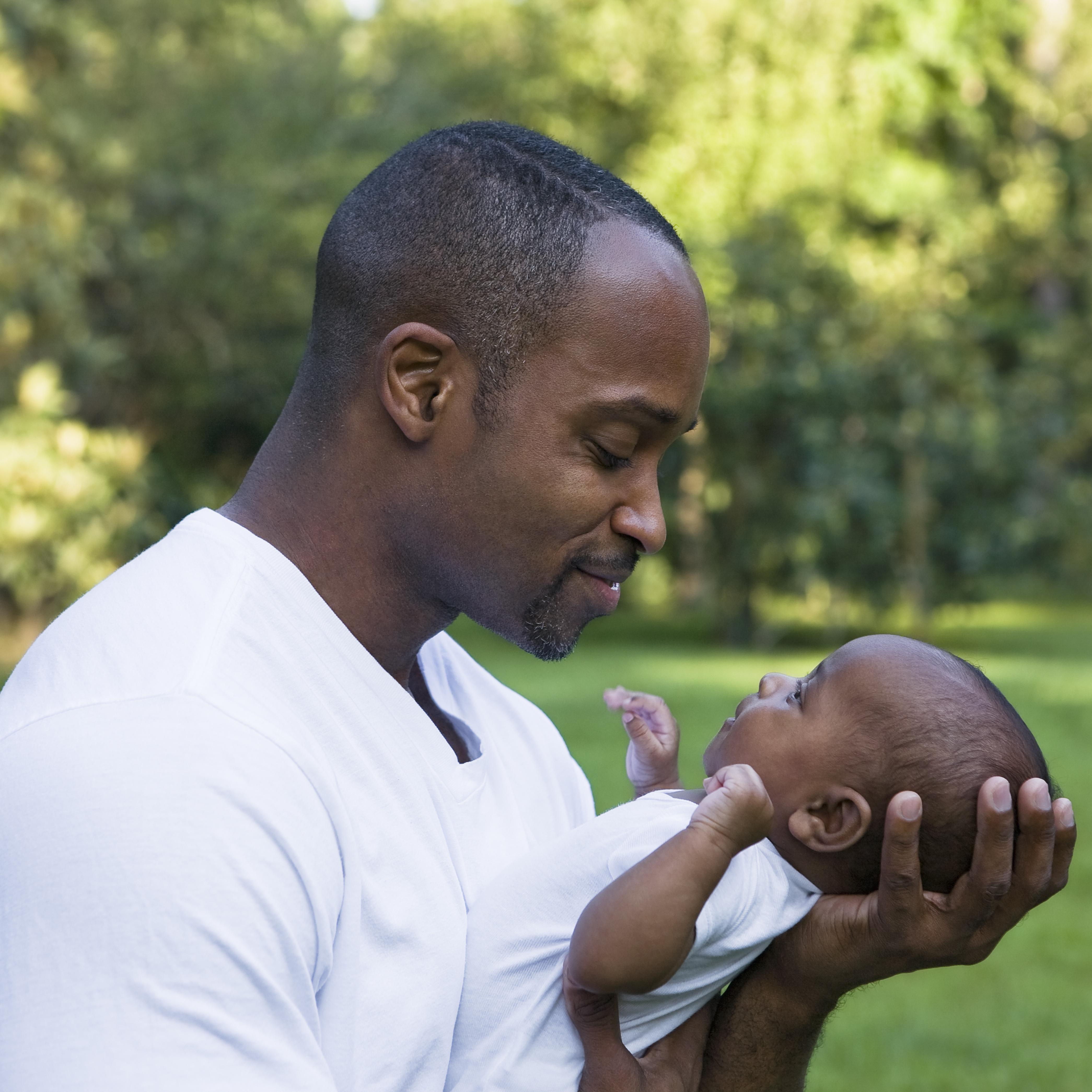 Father holding baby son (2-5 Months)
