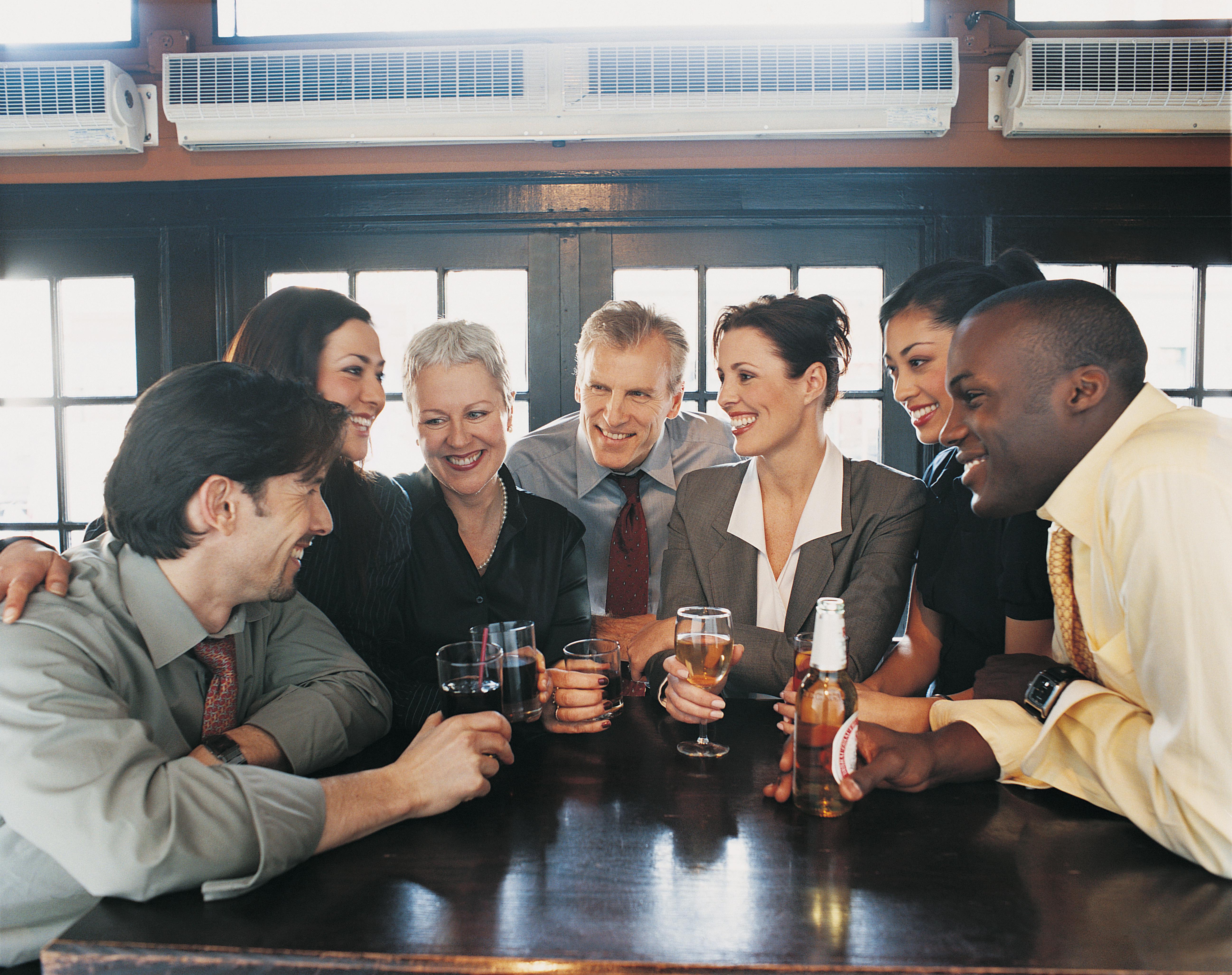 Businessmen and Businesswomen Work Colleagues Enjoying a Drink in a Bar